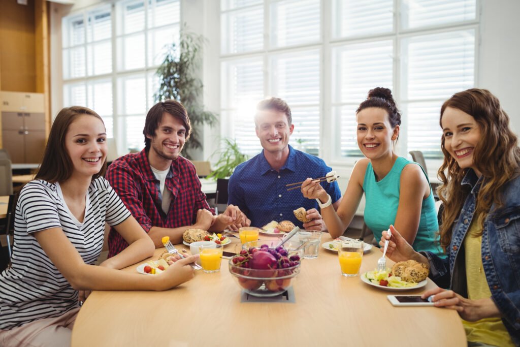 Grupo de ejecutivos en oficia comiendo fruta como snack saludable